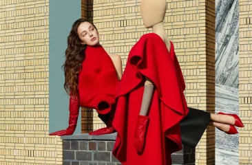 A woman in a red outfit next to a mannequin in similar colors.